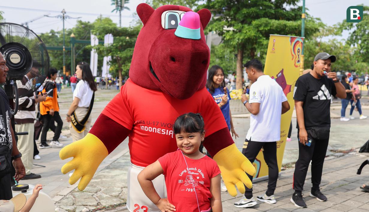 <p>Masyarakat yang menyaksikan kemeriahan Trophy Experience juga mendapatkan kesempatan berfoto dengan Maskot Piala Dunia U-17 2023, Bacuya, di Kota Solo, Minggu (5/11/2023). (Bola.com/Radifa Arsa)</p>
