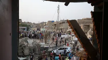 Orang-orang memeriksa tempat kejadian setelah ledakan di Kota Sadr di Baghdad, Irak, (7/6). Menurut pejabat setempat, sepasang ledakan bom menghancurkan sebuah masjid di distrik mayoritas Syiah di ibukota Irak. (AP Photo/Karim Kadim)