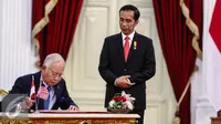 PM Malaysia, HE Dato Sri Muhammad Najib Tun Abdul Razak (kiri) mengisi buku tamu dampingi Presiden Jokowi di Istana Merdeka, Jakarta, Senin (1/8). Pertemuan membahas Konsultasi Bilateral Tahunan RI-Malaysia ke-11. (Liputan6.com/Faizal Fanani)