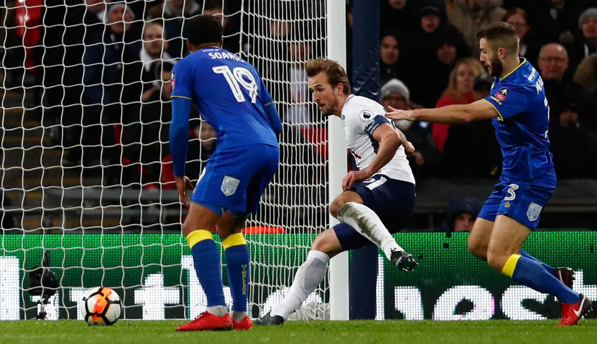 Striker Tottenham Hotspur, Harry Kane berhasil mencetak gol ke gawang Wimbledon pada pertandingan putaran ketiga FA Cup di Stadion Wembley, Minggu (7/1). Tottenham Hotspur lolos ke babak keempat Piala FA usai menang telak 3-0. (Adrian DENNIS/AFP)