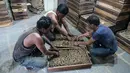 Pekerja menata rokok linting atau beedi pada wadah sebelum dikeringkan ke dalam tungku di sebuah pabrik di Nizamabad, India, 10 Oktober 2019. Penjualan rokok linting ala India ini telah mengalahkan rokok filter dengan perbandingan 8:1. (NOAH SEELAM/AFP)
