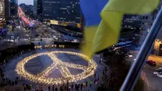 Orang-orang berdiri sekitar tanda perdamaian raksasa dengan pesan 'Hentikan Minyak Putin' jelang KTT Uni Eropa dan NATO di Brussels, Belgia, 22 Maret 2022. Pengunjuk rasa meminta para pemimpin Uni Eropa memberlakukan larangan penuh terhadap bahan bakar Rusia. (AP Photo/Geert Vanden Wijngaert)
