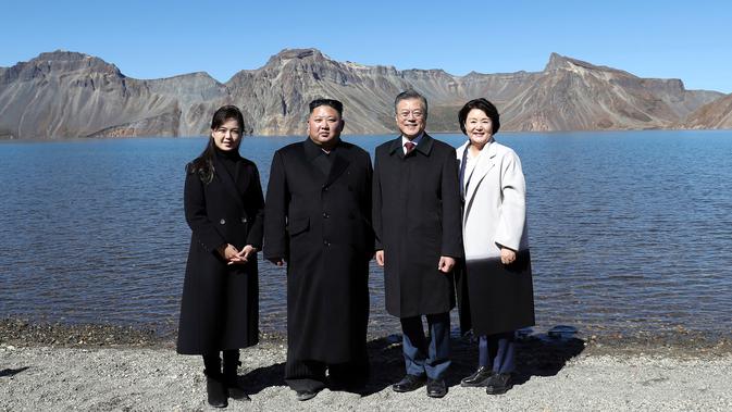 Presiden Korea Selatan Moon Jae-in (dua kanan) dan sang istri Kim Jung-sook (kanan) foto bersama Pemimpin Korea Utara Kim Jong-un (dua kiri) dan sang istri Ri Sol Ju (kiri) di Gunung Paektu, Korea Utara, Kamis (20/9). (Pyongyang Press Corps Pool via AP)