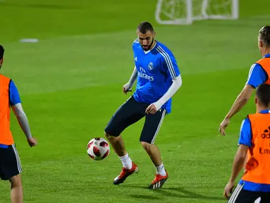 Striker Real Madrid, Karim Benzema menggiring bola saat latihan di stadion New York University Abu Dhabi, Uni Emirat Arab (17/12). Madrid akan bertanding melawan Kashima Antlers pada semifinal Piala Dunia Antarklub 2018. (AFP Photo/Giuseppe Cacace)