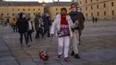 Orang-orang yang mengenakan masker berjalan di San Lorenzo de El Escorial, Spanyol, Minggu (2/1/2022). Pejabat Spanyol sebelumnya bangga dengan keberhasilan vaksinasi Covid-19 dimana 80% dari 47 juta orang di negara itu sudah mendapatkan dosis lengkap atau dua dosis vaksin. (AP Photo/Manu Fernandez)