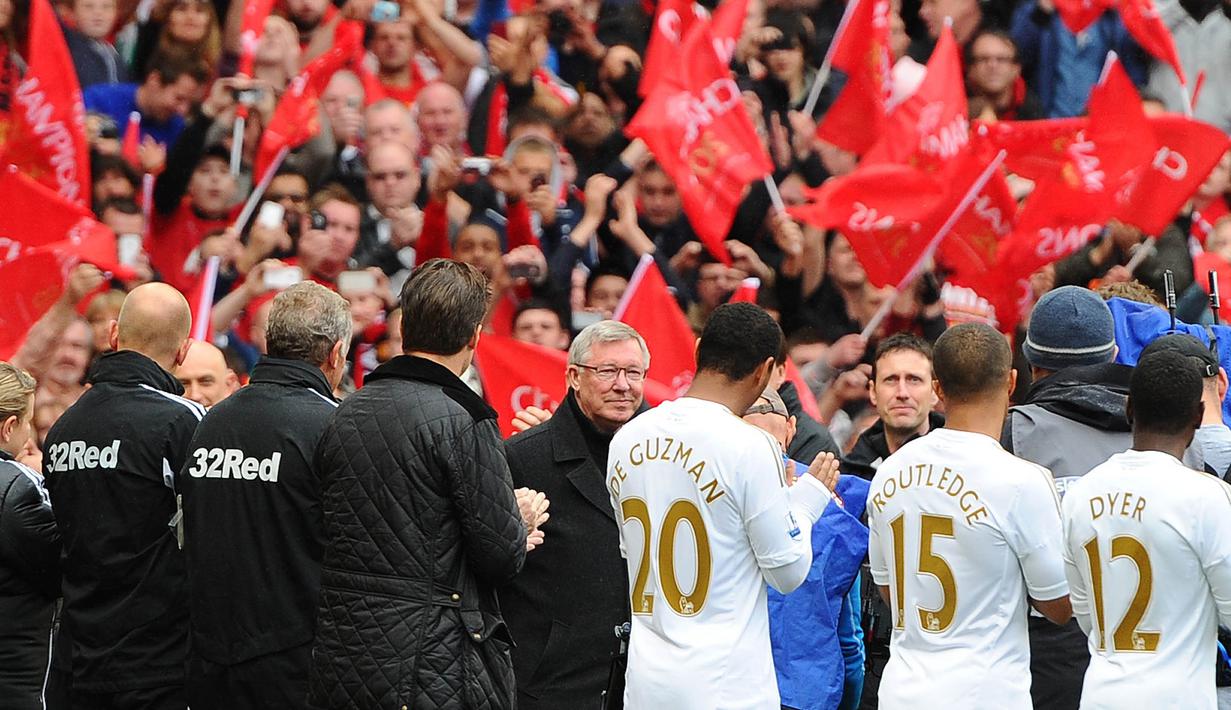 Pelatih Manchester United, Sir Alex Ferguson, disambut para pemain saat melawan Swansea City pada laga Premier League di Stadion Old Trafford (12/5/2013). Pertandingan tersebut sekaligus menjadi momen perpisahan Sir Alex Ferguson bersama Setan Merah. (AFP/Andrew Yates)