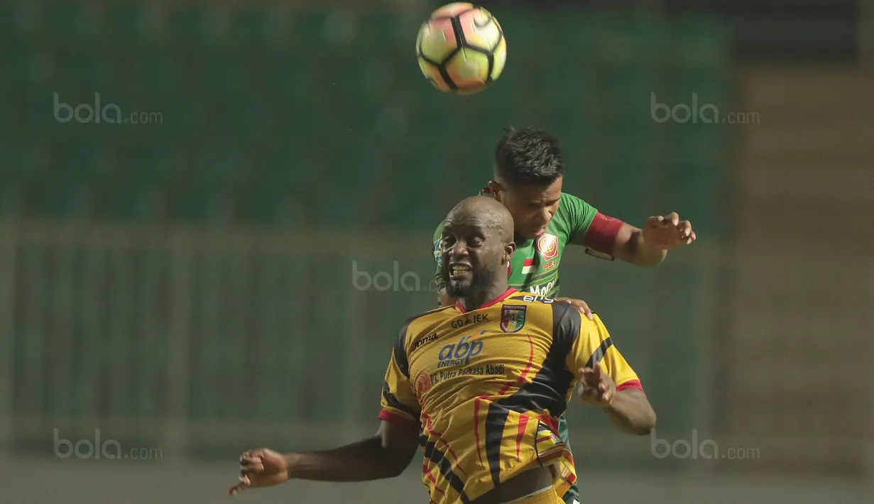 Pemain PS TNI, Manahati Lestusen (atas) berduel dengan pemain Mitra Kukar, Mohammed Sissoko pada lanjutan Liga 1 2017 di Stadion Pakansari, Bogor (26/9/2017). PS TNI menang 2-1. (Bola.com/Nicklas Hanoatubun)