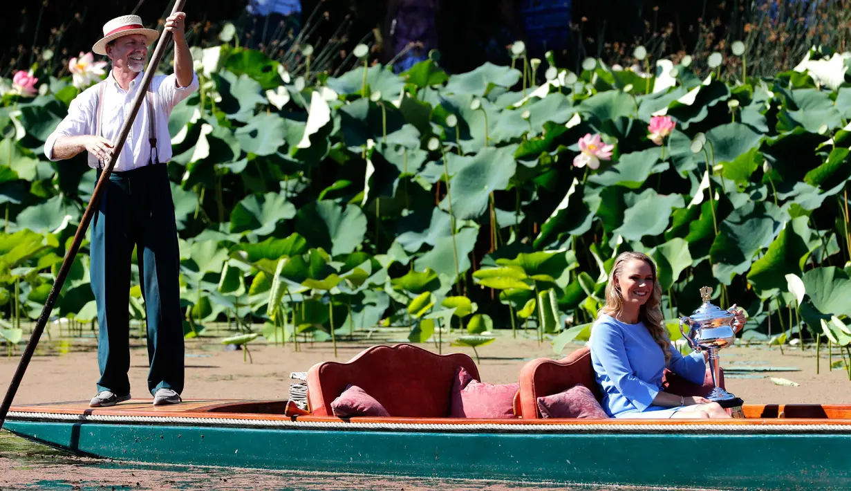 Caroline Wozniacki tersenyum sambil membawa piala Australia Terbuka 2018 saat berada di perahu kayu dalam Daphne Akhurst Memorial Cup di Royal Botanical Gardens di Melbourne, Australia, (28/1). (AP Photo/Ng Han Guan)