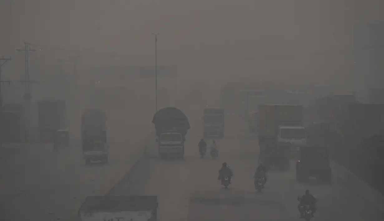 Kendaraan melewati jembatan di tengah kondisi kabut asap tebal di Lahore, Pakistan, pada 17 November 2021.  Situasi mengerikan tersebut telah membuat para warga Lahore meminta para pejabat tinggi kota untuk segera mencari solusi untuk menghentikan pencemaran polusi di kota itu. (Arif ALI/AFP)