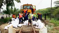 Petugas Daops VIII Surabaya menaruh karung mengantisipasi banjir di perlintasan kereta di Porong, Sidoarjo, Jawa Timur. (Liputan6.com/Dhimas Prasaja)