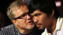 Petinju Filipina, Manny Pacquiao (kanan), mendengarkan arahan pelatihnya, Freddie Roach, dalam jumpa pers jelang laga melawan Chris Algieri di Shanghai, Tiongkok, (26/8/2014). (REUTERS/Carlos Barria)
