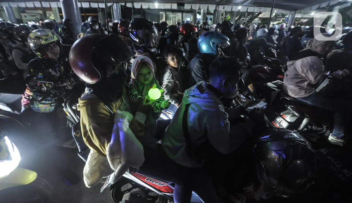 <p>Pemudik bersama anaknya saat antre memasuki kapal di Pelabuhan Merak, Cilegon, Banten, Sabtu (30/4/2022) dini hari. Antrean pemudik sepeda motor masih mewarnai arus mudik di Pelabuhan Merak pada H-2 Lebaran atau Puncak Arus Mudik yang terjadi hari ini. (merdeka.com/Iqbal S. Nugroho)</p>