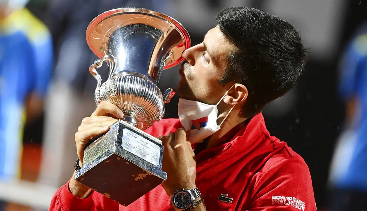 Petenis Serbia, Novak Djokovic, mencium trofi usai menjuarai Italia Terbuka di Roma, Senin (21/9/2020). Djokovic mengalahkan petenis Argentina, Diego Schwartzman, dengan skor 7-5 dan 6-3. (Alfredo Falcone/LaPresse via AP)