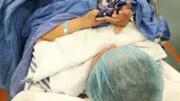 Selama 18 menit dioperasi, ia asyik bermain ponsel dan memotret jalannya operasi.