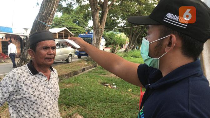 Pemeriksan suhu tubuh di perbatasan Sulteng terhadap pelintas. (Foto: Liputan6.com/ Heri Susanto).