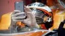 Pebalap McLaren asal Belgia, Stoffel Vandoorne menggunakan handphone untuk foto selfie saat sesi  latihan bebas F1 GP China di Shanghai, (6/4/2017). (AFP/Wang Zhao)