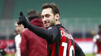 Pemain AC Milan, Hakan Calhanoglu, merayakan kemenangan atas Torino pada laga Coppa Italia di Stadion San Siro, Selasa (12/1/2021). AC Milan menang adu penalti dengan skor 5-4. (AP/Antonio Calanni)
