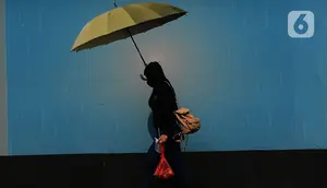 Pejalan kaki mengenakan payung untuk menghindari panas matahari di kawasan Kuningan, Jakarta, Selasa (26/9/2023). (merdeka.com/Imam Buhori)