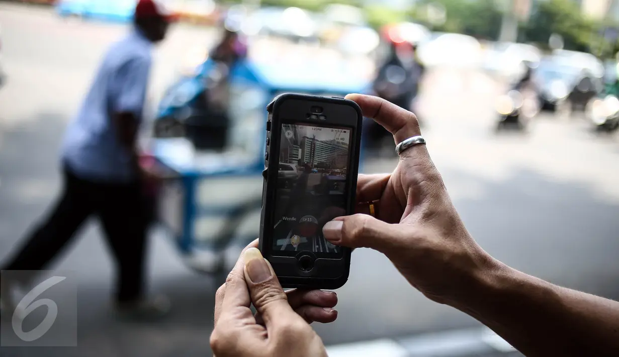 Karakter Pokemon terlihat di dekat pedagang keliling pada layar smartphone pemain augmented reality game Pokemon Go di Jakarta, Kamis (14/7). Pokemon Go sedang di puncak ketenaran meski baru diluncurkan di beberapa negara. (Liputan6.com/Faizal Fanani)