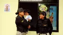 Petugas lapas menggendong seorang anak di taman kanak-kanak penjara wanita Santa Monica, Lima, Peru (31/10). (Reuters/Mariana Bazo)