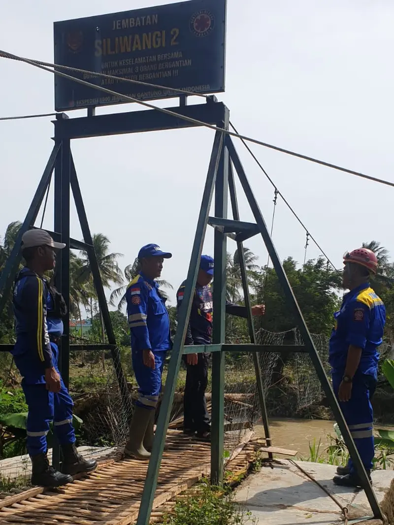 Beberapa anggota relawan Tagana Garut tengah memeriksa jembatan Siliwangi 2 di Desa Mandalakasih, Kec. Pameungpeuk, Garut, yang roboh diterjang banjing bandang beberapa waktu. (Liputan6.com/Jayadi Supriadin).