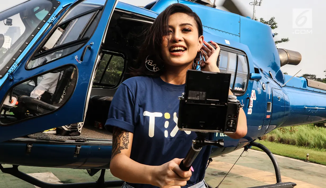 Penyanyi Awkarin usai menemani para pemenang kompetisi foto #TIXCOPTER berkeliling naik helikopter di Jakarta, Rabu (25/7). Acara ini diselenggarakan oleh TIX ID bekerja sama dengan Dompet Digital Indonesia (DANA). (Liputan6.com/JohanTallo)