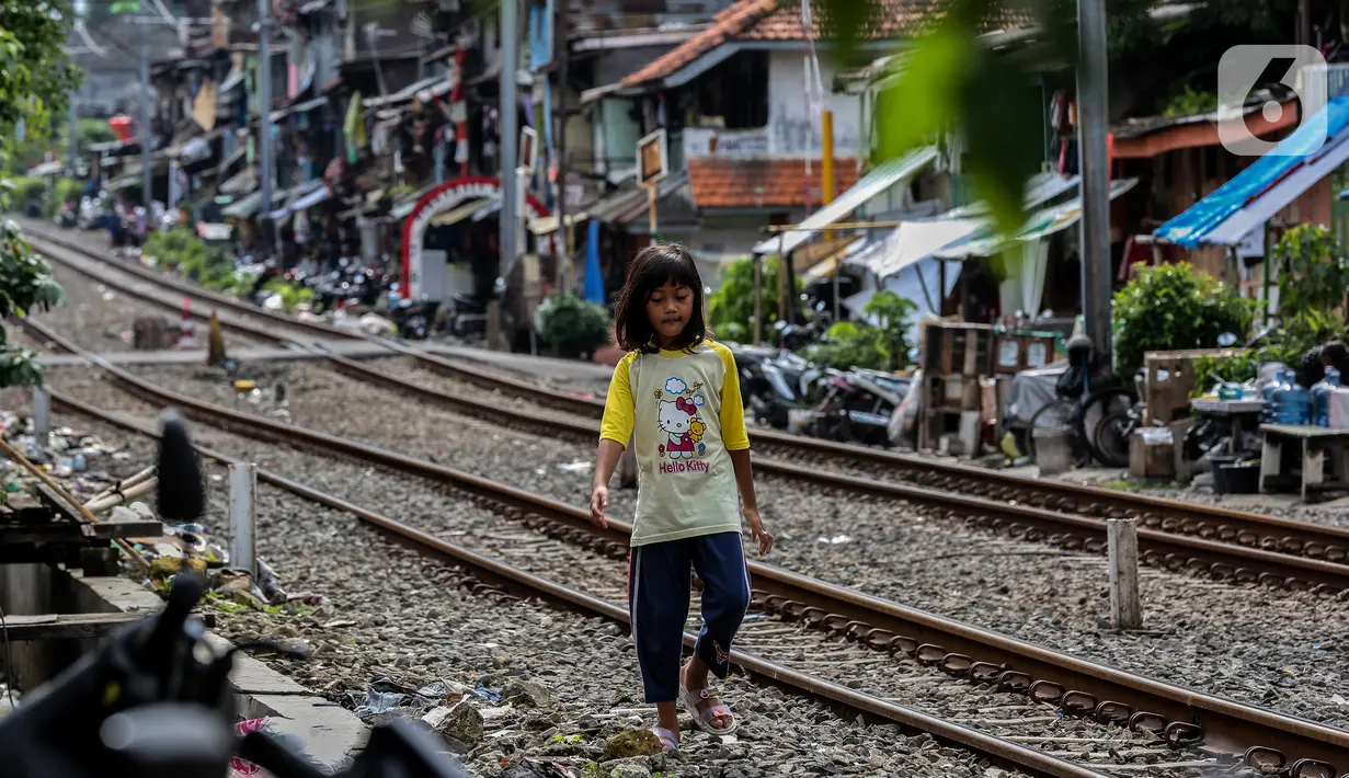 Seorang anak berjalan di bantaran rel kawasan pemukiman padat Pejompongan, Jakarta, Kamis (28/1/2020). Dalam  jangka  waktu  sepuluh  tahun  sejak  tahun  2010,  jumlah  penduduk DKI   meningkat  954  ribu  jiwa,  atau  rata-rata  sebanyak  88  ribu  jiwa  setiap tahun. (Liputan6.com/Johan Tallo)
