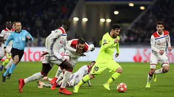Penyerang Barcelona Lionel Messi (dua kanan) menggiring bola melewati para pemain Lyon pada leg pertama babak 16 besar Liga Champions di Decines, Lyon, Prancis, Selasa (19/2). Laga berakhir 0-0. (AP Photo/Laurent Cipriani)
