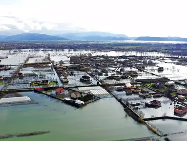 Air hujan membanjiri Desa Obot, sekitar 100 kilometer (60 mil) barat laut Tirana, Albania, Senin (11/1/2021). Hujan deras dan salju selama beberapa hari terakhir telah membanjiri banyak kawasan di Albania. (AP Photo/Hektor Pustina)