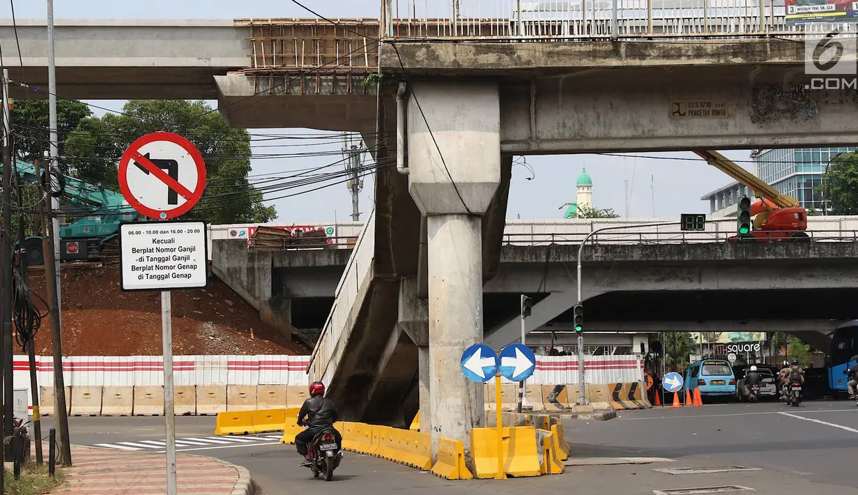 Kendaraan melintas di dekat tangga JPO yang berada di tengah jalan Dewi Sartika, Jakarta, Rabu (9/1). Adanya proyek pelebaran jalan menyebabkan posisi trotoar bergeser sehingga tangga JPO menjadi di tengah jalan. (Liputan6.com/Immanuel Antonius)