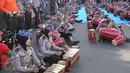 Aksi polisi dan polwan memainkan alat musik gamelan dan gendang pada kegiatan car free day di Jakarta, Minggu (9/4). Dalam atraksi tersebut mereka melakukan sosialisasi “Polwanku Sahabatku”. (Liputan6.com/Angga Yuniar)