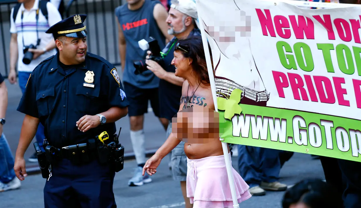 Petugas polisi berbincang dengan pengunjuk rasa saat  GoTopless Parade di New York, Amerika Serikat (28/8). Parade GoTopless Day telah ada di New York sejak 1992 silam. (AFP PHOTO / KENA Betancur)