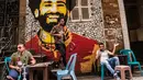Ahmed Fathy (tengah) menuruni tangga dekat mural bintang Liverpool, Mohamed Salah di sebuah kedai kopi di pusat kota Kairo, 30 April 2018. Mural pemain timnas Mesir tersebut merupakan hasil karya Fathy. (AFP Photo/KHALED DESOUKI)
