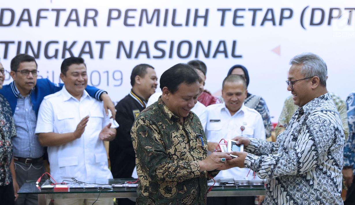 Ketua KPU RI, Arief Budiman (kanan) menyerahkan soft copy DPT tingkat nasional kepada Ketua Bawaslu RI, Abhan usai rapat pleno di Jakarta, Rabu (5/9). Sebelumnya, KPU menggelar rapat pleno rekapitulasi DPT nasional. (Liputan6.com/Helmi Fithriansyah)