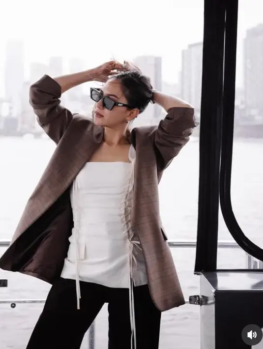 Jessica Mila mengenakan outer coklat dipadukan inner sleeveless putih dengan aksen tali. Dipadukan celana hitam panjang. [@jscmila]