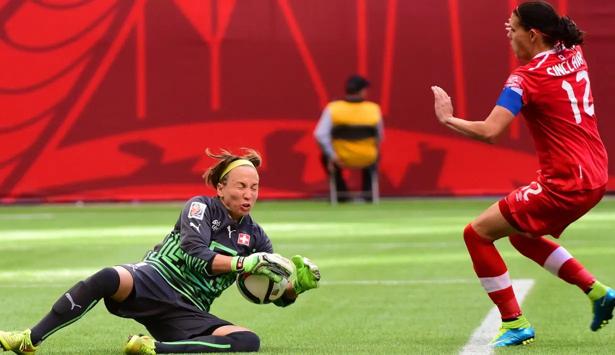 Kiper Swiss, Gaelle Thalmann menangkap bola dari kejaran penyerang Kanada, Christine Sinclair saat Piala Dunia wanita 2015 di BC Place Stadium, Senin (22/6/2015). Kanada menang 1-0 atas Swiss lewat gol Josee Belanger. (Reuters/Anne Marie Sorvin)