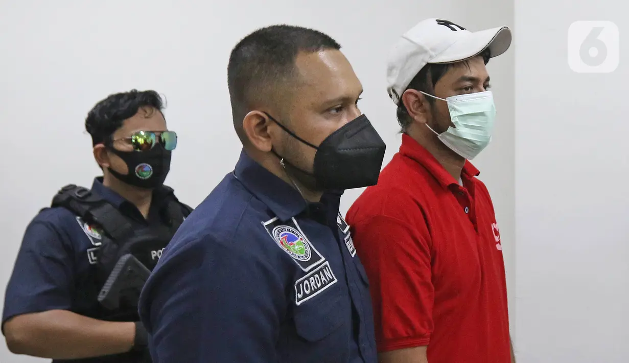 Petugas membawa artis peran Rio Reifan untuk dihadirkan dalam rilis kasus narkoba di Polres Metro Jakarta Pusat, Rabu (21/4/2021). Rio Reifan tertangkap basah ketika polisi menggeledah rumahnya saat memesan sabu melalui ojek online dengan berat 1 gram. (Liputan6com/Herman Zakharia)