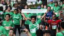 Peserta menunjukkan tulisan saat sampai di garis finis dalam Lomba lari MILO Jakarta International 10K 2017, Jakarta, Minggu (23/7). MILO Jakarta International 10K 2017 melombakan tiga kategori 10K, 5K dan Family Run 1,7K. (Liputan6.com/Faizal Fanani)