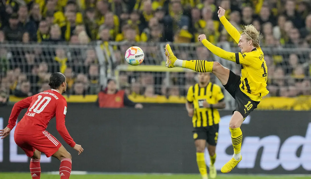 Gelandang Borussia Dortmund Julian Brandt meraih bola di depan penyerang Bayern Munchen  Leroy Sane dalam laga lanjutan Bundesliga, kasta tertinggi Liga Jerman, musim 2022-2023, di Signal-Iduna Park, Sabtu (9/10/2022). Pertandingan berjalan dengan ketat, Dortmund dan Bayern mengerahkan kemampuan terbaik dalam duel sarat gengsi ini. (AP Photo/Martin Meissner)