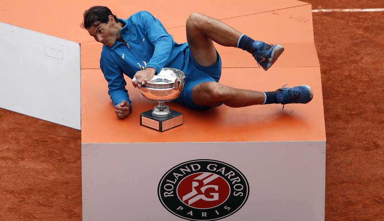 Rafael Nadal saat melakukan sesi foto dengan trofi Prancis Terbuka 2018 di Roland Garros stadium, Paris, (10/6/2018). Nadal menang atas Dominic Thiem tiga set 6-4, 6-3, 6-2. (AP/Christophe Ena)
