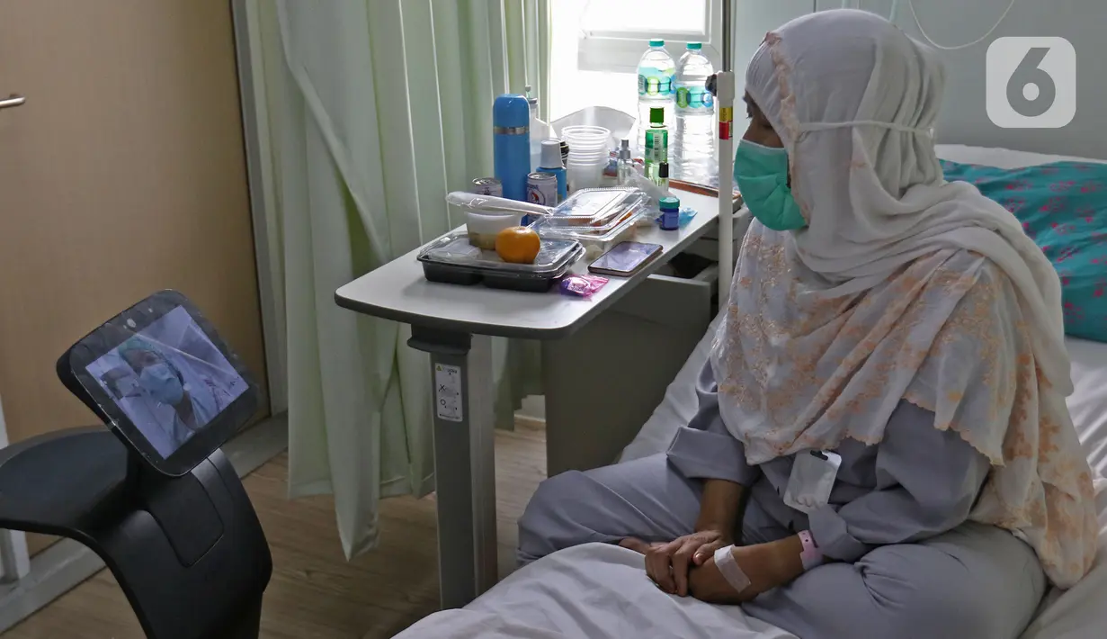 Pasien sedang video call dengan perawat menggunakan robot Temi saat di  kamar pasein  RSPJ Modular, Jakarta, Selasa (28/7/2020). Teknologi robot ini juga dapat mengantarkan makanan dan menghibur para pasien dengan cara mendengarkan lagu dan senam bersama. (Liputan6.com/Herman Zakharia)
