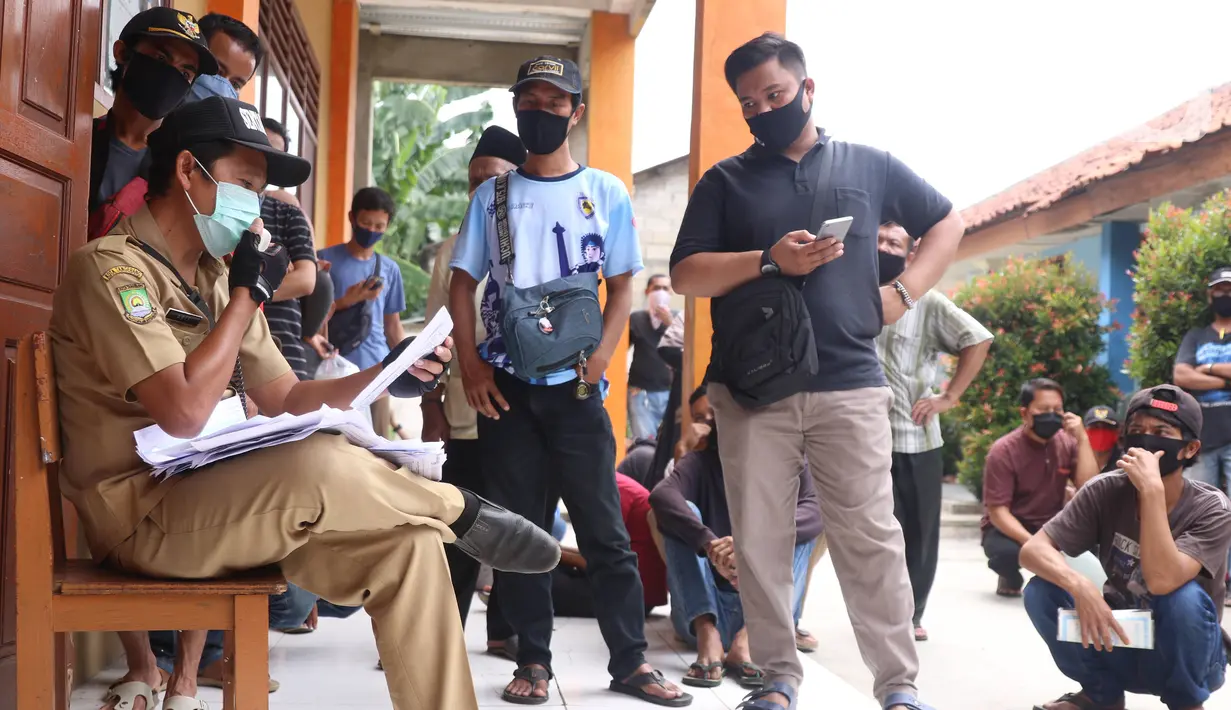 Warga mengantre untuk mendapatkan bantuan sosial (bansos) yang diberikan Pemerintah Provinsi Banten di Pinang, Tangerang, Jumat (1/5/2020). Bansos berupa uang tunai sebesar Rp 600 ribu tersebut diberikan kepada warga yang terdampak virus corona COVID-19. (Liputan6.com/Angga Yuniar)