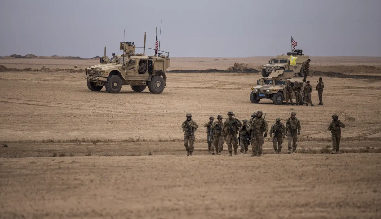 Tentara Amerika berjalan selama latihan bersama dengan Pasukan Demokrat Suriah di pedesaan Deir Ezzor di timur laut Suriah (8/12/2021). Puluhan tentara Amerika dan Pasukan Demokrat Suriah berpartisipasi dalam latihan bersama satu hari.  (AP Photo/Baderkhan Ahmad)