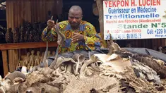 Lucien Yekpon, seorang dukun Lome berdiri di depan lapak dagangannya di pasar jimat Akodessewa di Togo, Afrika, 5 Agustus 2015. Pasar ini menjual berbagai benda-benda klenik dan juga peralatan sihir. (AFP PHOTO/EMILE KOUTON) 