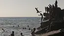 <p>Warga Palestina bermain air di pantai Beit Lahia di Jalur Gaza utara saat para siswa memulai liburan musim panas mereka pada 3 Juni 2022. Sejumlah warga menikmati musim panas dengan berenang dan bermain air di pantai. (MOHAMMED ABED / AFP)</p>