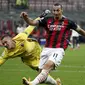 Pemain AC Milan Zlatan Ibrahimovic (kanan) menendang bola saat penjaga gawang Bologna Lukasz Skorupski mencoba menghentikannya pada pertandingan Serie A di Stadion San Siro, Milan, Italia, Senin (21/9/2020). AC Milan menaklukkan Bologna 2-0. (AP Photo/Antonio Calanni)