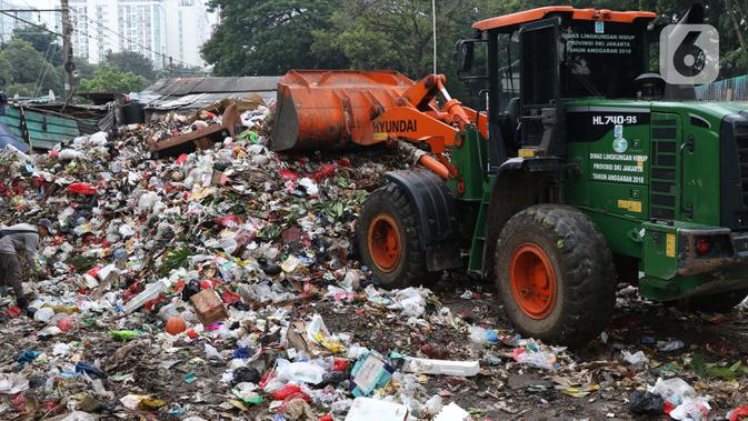 Petugas mengoperasikan alat berat untuk memindahkan sampah di Tempat Pembuangan Sementara Kalibata, Jumat (10/4/2020). Kadis Lingkungan Hidup DKI Jakarta, Andono Warih mengatakan terjadi penurunan tonase sampah rata-rata 620 ton per hari selama penerapan WFH. (Liputan6.com/Helmi Fithriansyah)