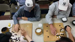 Pria bermain Baduk, versi Go Korea, di pusat Layanan Komunitas Korea di New York (10/8). Sekitar 100.000 orang Korea tinggal di New York City. (AFP Photo/Don Emmert/To Go With AFP STORY by Jennie Matthew, NKorea-US-nuclear-diaspora)