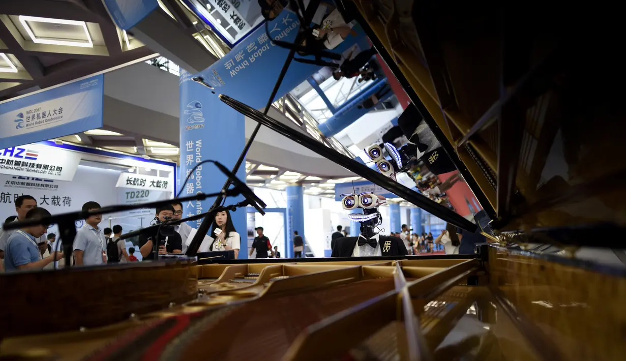 Aksi robot "Teotronico" menunjukkan kebolehannya memainkan piano dalam acara Konferensi Robot Dunia 2017 di Beijing, 23 Agustus 2017. Selain bisa memainkan piano, robot rancangan Matteo Suzzi ini juga dapat menyanyikan lagu-lagu populer. (WANG Zhao/AFP)