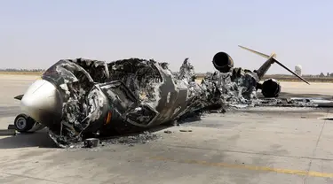 Sisa reruntuhan sebuah pesawat terlihat di Bandara Internasional Tripoli, Libya, (21/7/2014). (REUTERS/Hani Amara)